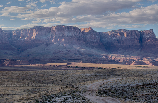 shafts of light spill across house rock valley from slot canyons in the vermilion cliffs